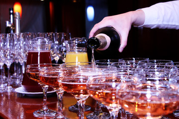 A man's hand pours champagne from a bottle