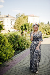 Portrait of blonde girl in wreath wear on long dress at hen party.