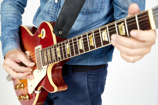 Chitarrista con chitarra elettrica rossa e giacca di jeans