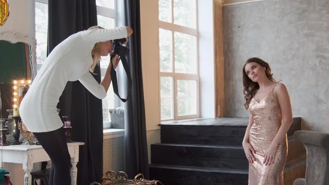 Photographer takes pictures of model. Wide shot