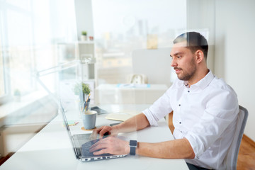 Naklejka na ściany i meble happy businessman typing on laptop at office