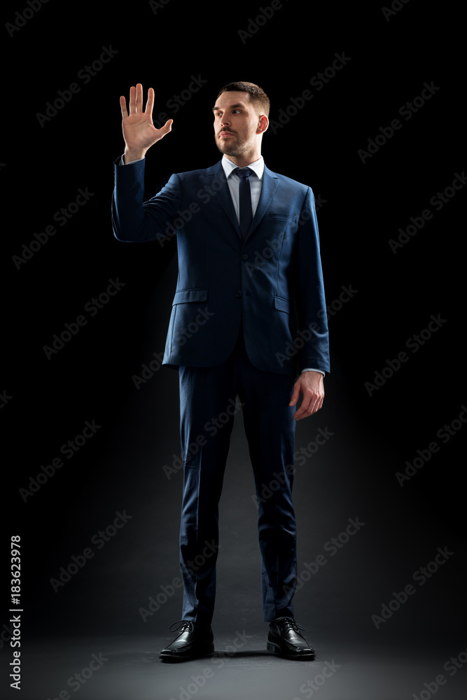 Poster businessman in suit touching something invisible