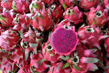 Pile of Red dragon fruit on table. Also known as pitaya or pitahaya. Origin from South America....