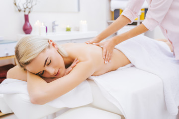 Obraz na płótnie Canvas beautiful young woman getting back massage at spa salon