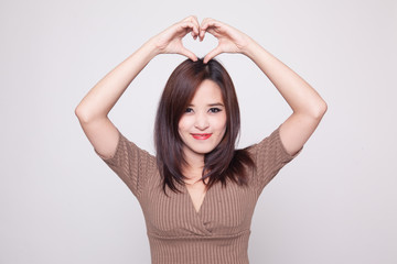 Fototapeta premium Young Asian woman gesturing heart hand sign.