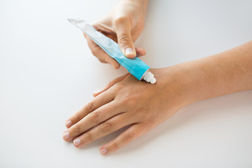 close up of hands with cream or therapeutic salve
