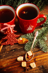 Picture of beautiful Christmas table setting, shining white plate with red cup for coffee decorated holiday dinner, branch of berry and santa claus star on festive dishware, New Year party, xmas eve