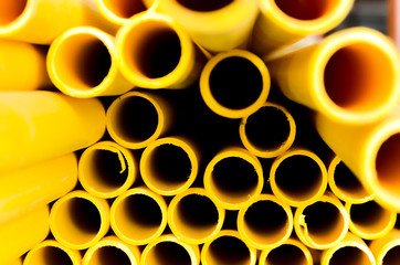 Yellow PVC tubes in storage, Plastic tubes, Background of PVC,Water pipes wallpaper background.