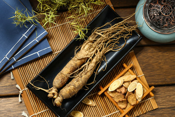 .ginseng in black plate on wooden table