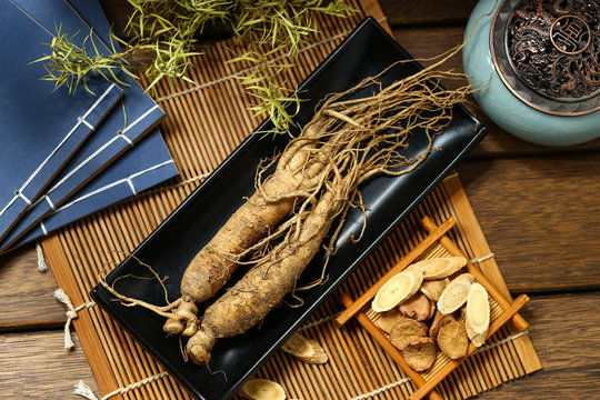 .ginseng in black plate on wooden table