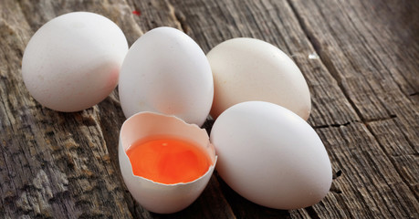 White fresh chicken eggs on wooden surface. Close up view.