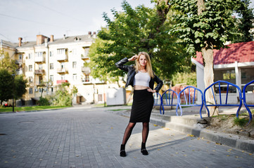 Naklejka premium Elegant blonde girl wear on black leather jacket posing at streets of town.