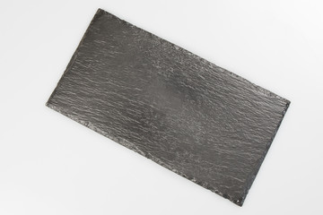 Blank black stone plate isolated on white background with copy space