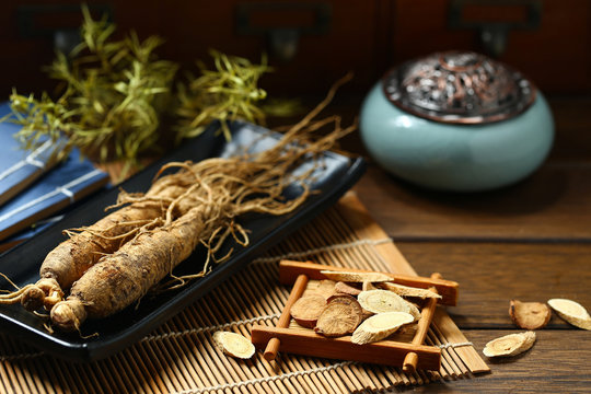 .ginseng in black plate on wooden table