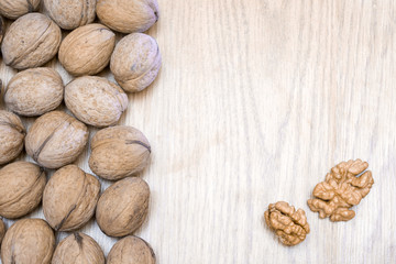 Isolated walnut in shell and peeled walnut kernel on a wooden table. Healthy food. Place for text.