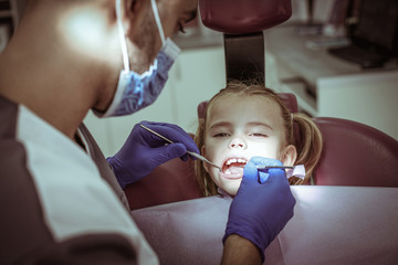 Little girl at dentist surgery. Close up.