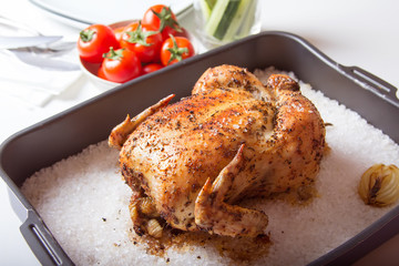Chicken baked on salt. Selective focus, close-up.