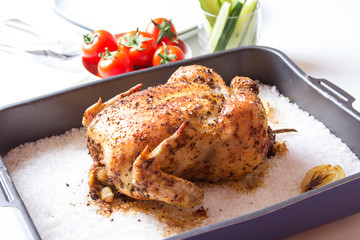 Chicken baked on salt. Selective focus, close-up.