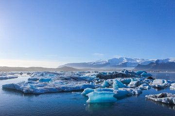 wide landscape of icebergs floating on the water under the very clear blue sky with copy space