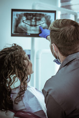 Dentist talking with patient about x-ray clip.