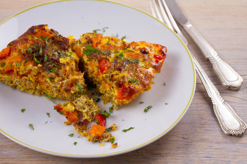 Frittata made with  eggs, beef sausage, pumpkin (or butternut squash) and red bell pepper, horizontal