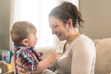 Young mother playing with her toddler at home