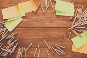 Sticky notes and color pencils on wooden desk