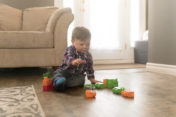 child boy building from toy blocks at home