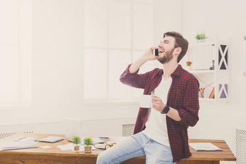 Young concentrated businessman read documents in modern white office