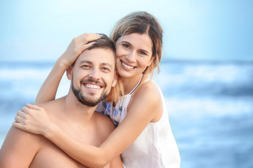 Obraz premium Happy couple on sea beach at resort