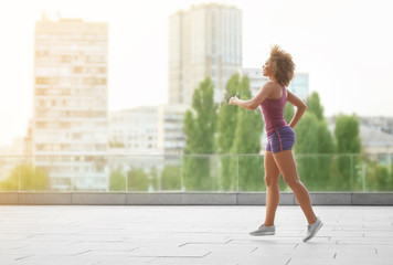 Sporty African American woman running outdoors