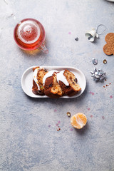 Slices of traditional christmas cake with dried fruits soaked in rum and sugar glaze. Teatime with heart-shaped ginger cookies. Christmas background with festive decoration.