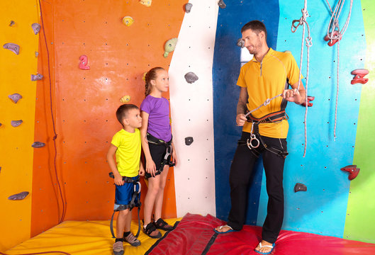 Little children with trainer in climbing gym