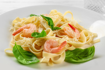 Tasty pasta with shrimps and grated cheese on plate, closeup