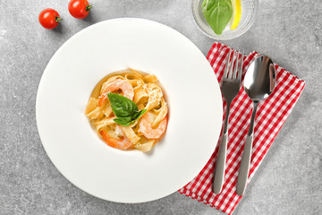 Plate of tasty pasta with shrimps on table, top view