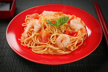 Plate of tasty pasta with shrimps on table
