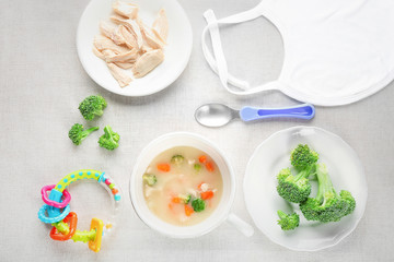 Breakfast with mug of creamy soup for baby on table