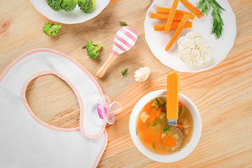 Breakfast with plate of tasty soup for baby on table