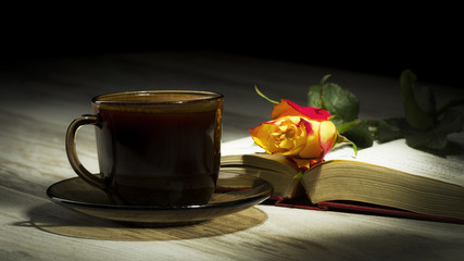 Cup of the coffee relating to the book with the rose