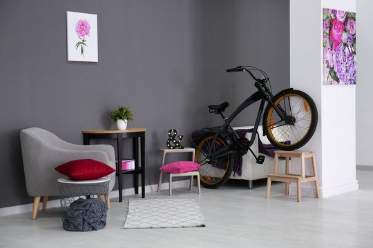 Modern room interior with grey armchair and bicycle