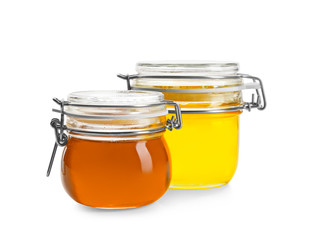Jars with aromatic honey on white background