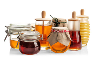 Jars with aromatic honey on white background