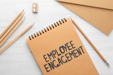 Notepad with text EMPLOYEE ENGAGEMENT on table