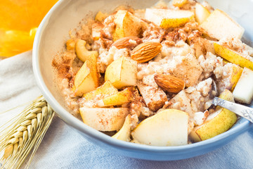 Porridge bowl oatmeal top view with fruit healthy breakfast on sunny morning table.