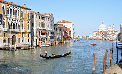 Obraz na płótnie Canvas a gondola sails along the beautiful Grand canal, the Basilica di Santa Maria della Salute in Venice, Italy