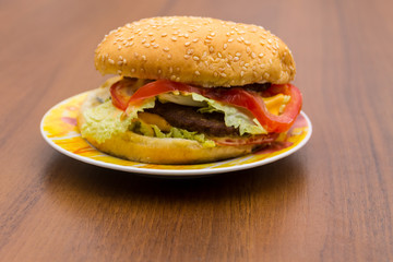 Delicious hamburger or sandwich on plate on wooden table