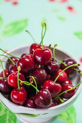 Bowl of red cherries on colorful background