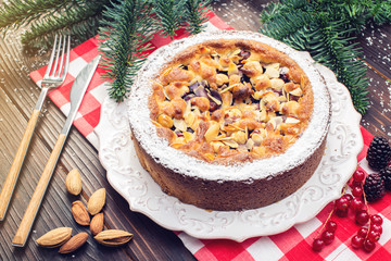 Homemade Christmas or New Year holiday berry pie with nuts on wooden table background. Concept of festive desserts