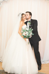 Wedding photo shoot of the newlyweds couple in a beautiful hotel posing near window