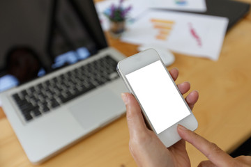 business woman using smart-phone on wooden table with laptop